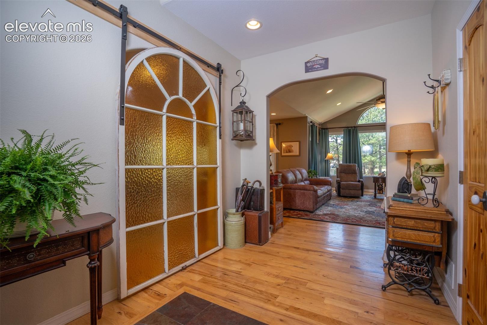 A 100+ year old stain glass window from the owner's childhood church, has been repurposed into a barn door to separate the entry from the kitchen when needed