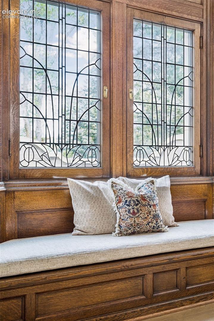 A wide main staircase is built into the north wall, positioned beneath four soaring floor-to-ceiling bay windows of beveled glass imported from Belgium