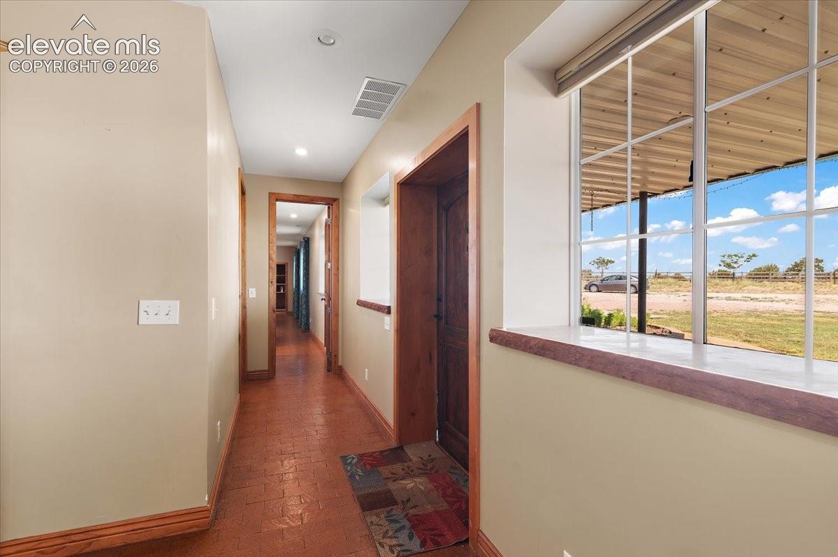 Looking down the hallway toward the primary bedroom, laundry room, mud room and hall bath.