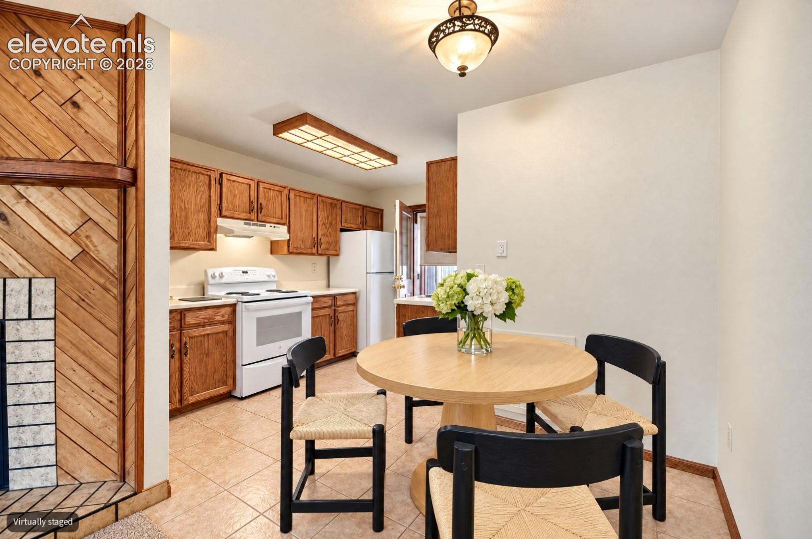 Kitchen featuring wood cabinetry, integrated white appliances, and a tiled floor