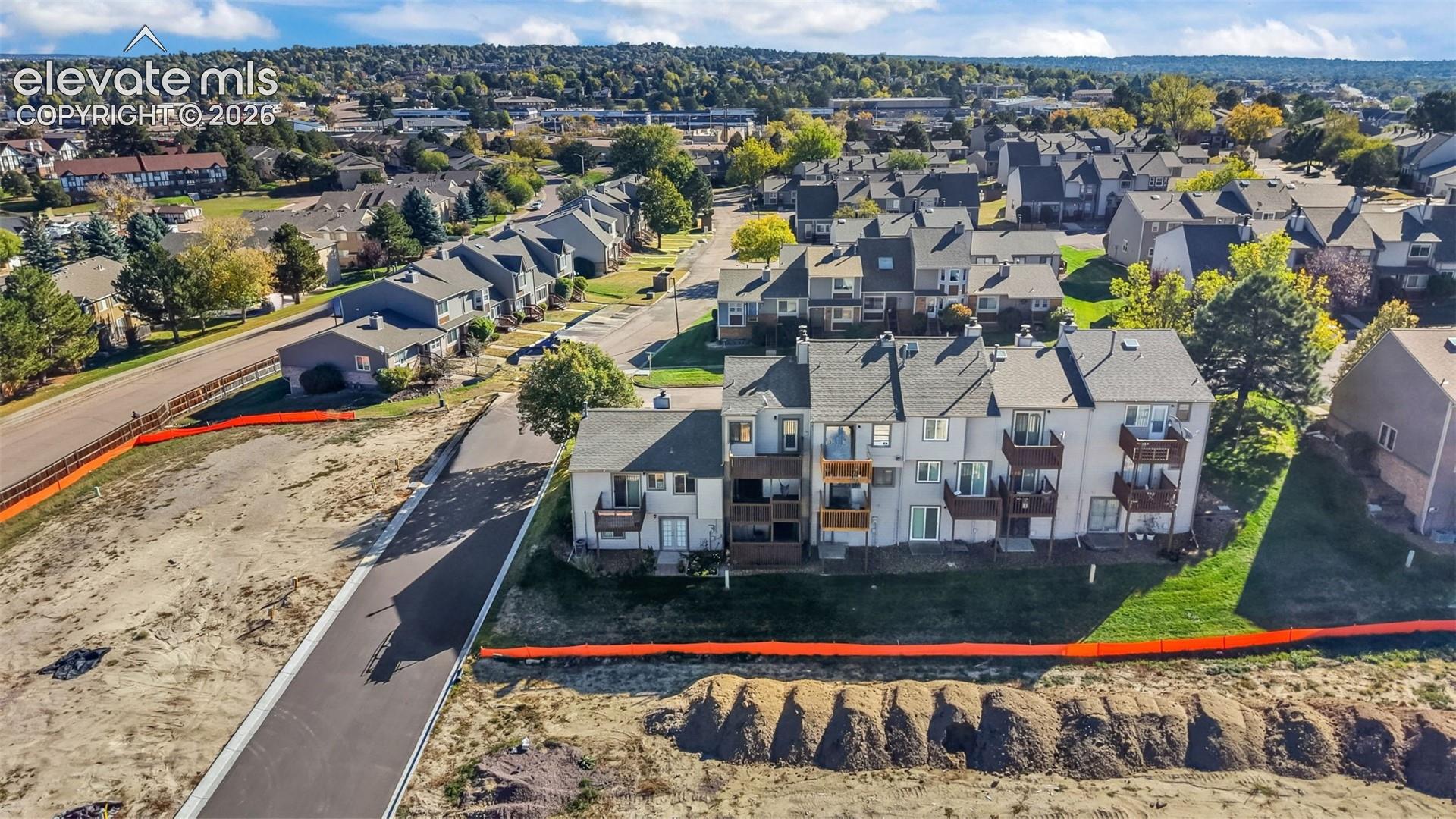 Aerial perspective of multi-level residential structures featuring wood-tone balconies and asphalt shingle roofing