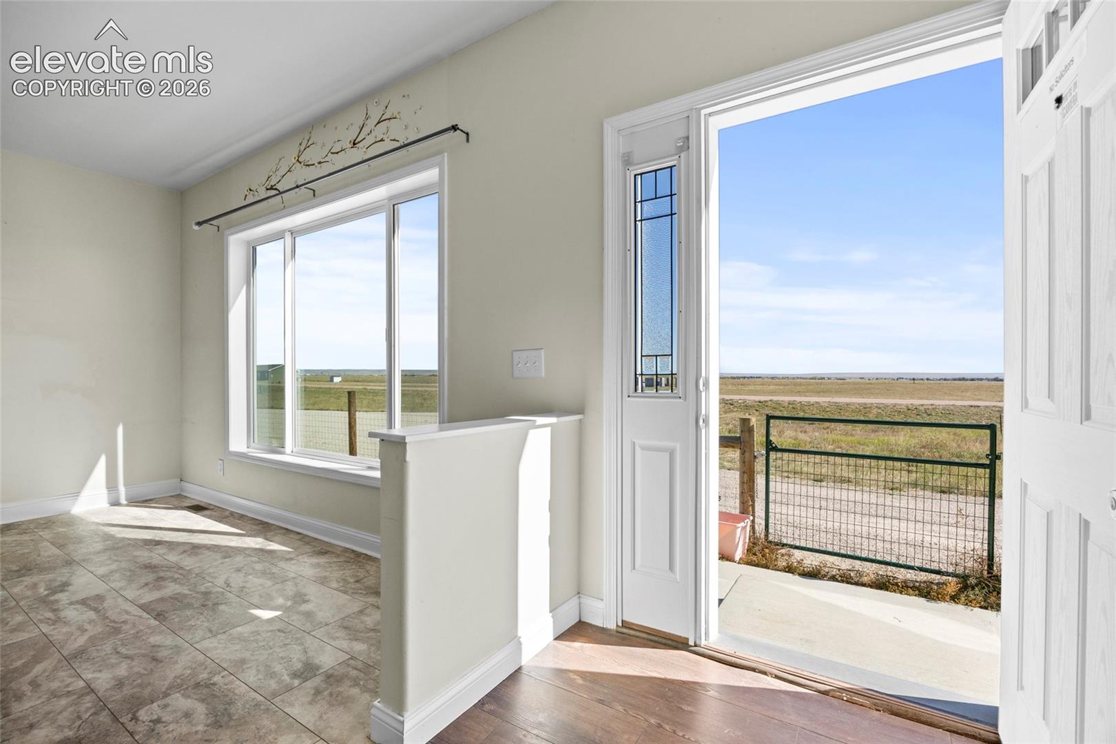 Entryway featuring tile flooring, a half-wall partition, and a glass-paneled exterior door