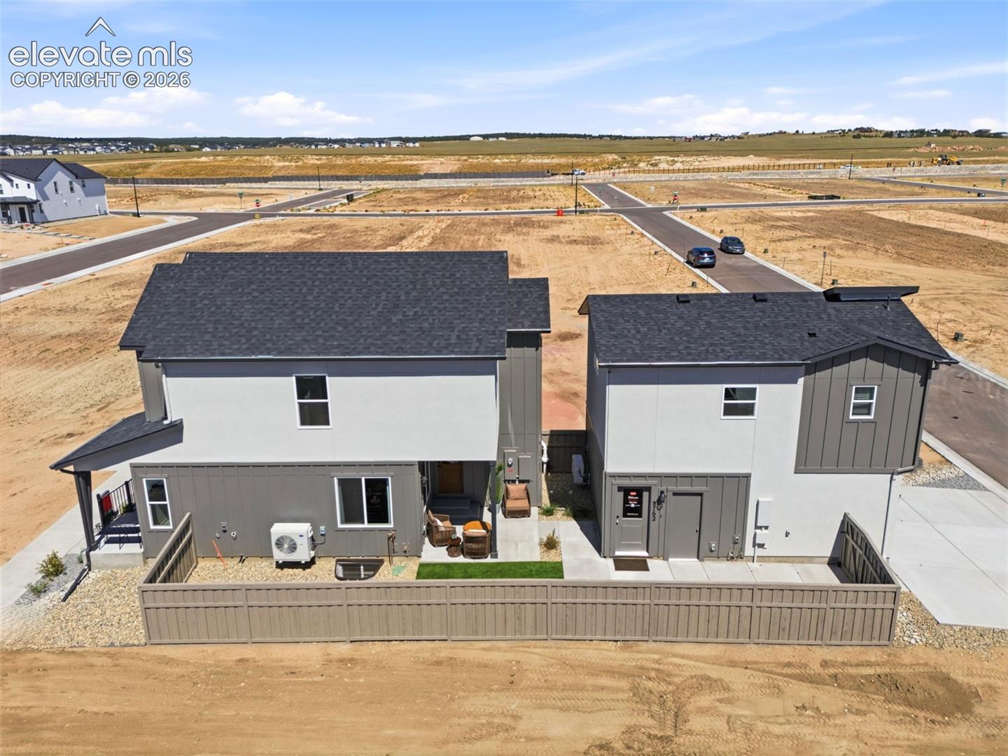 Aerial view of primary home with detached garage and ADU above.