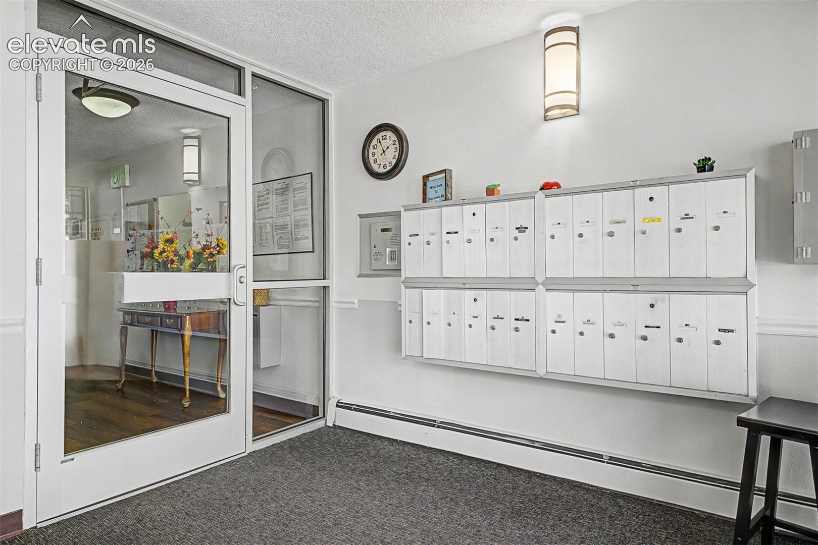 Entryway featuring secured mailboxes and a glass-paneled access door