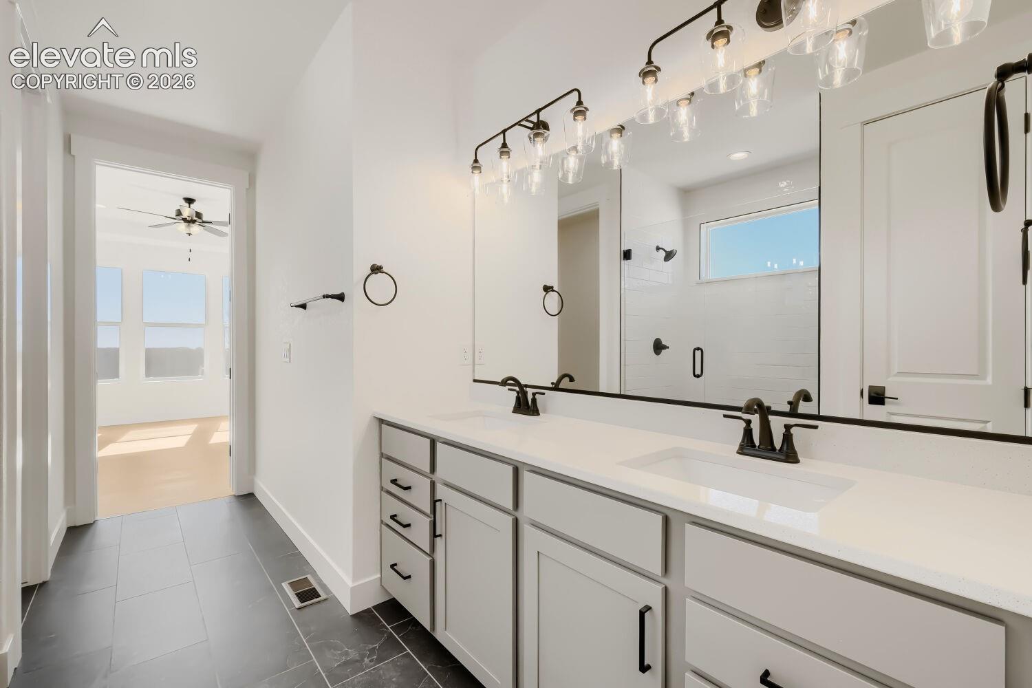 Dual vanity with white countertops, undermount sinks, and matte black fixtures