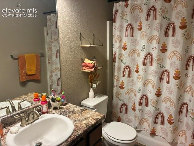 Bathroom featuring a vanity with a patterned countertop, integrated oval sink, brushed metal faucet, and wall-mounted shelving