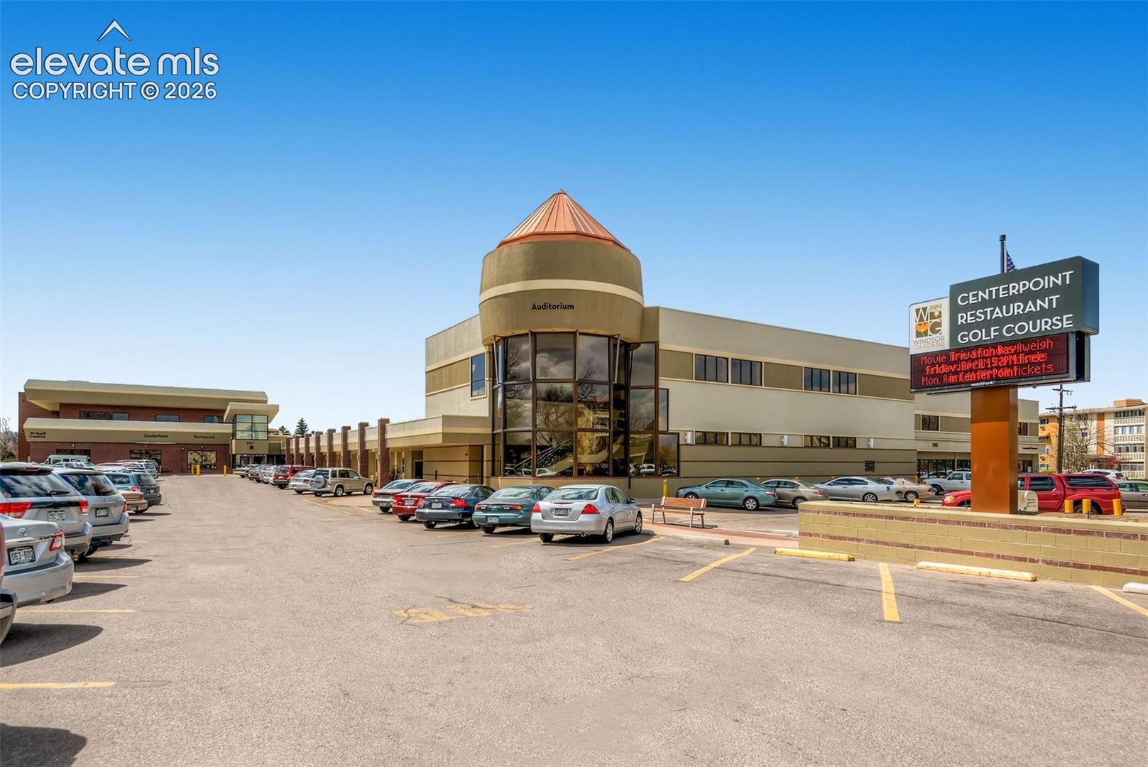 Commercial building featuring a prominent circular architectural element with a conical roof