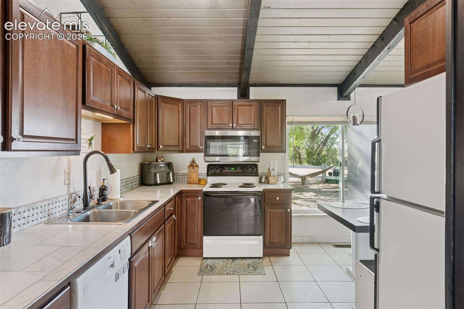Kitchen featuring ample cabinetry, full appliance package with direct access to outdoor space