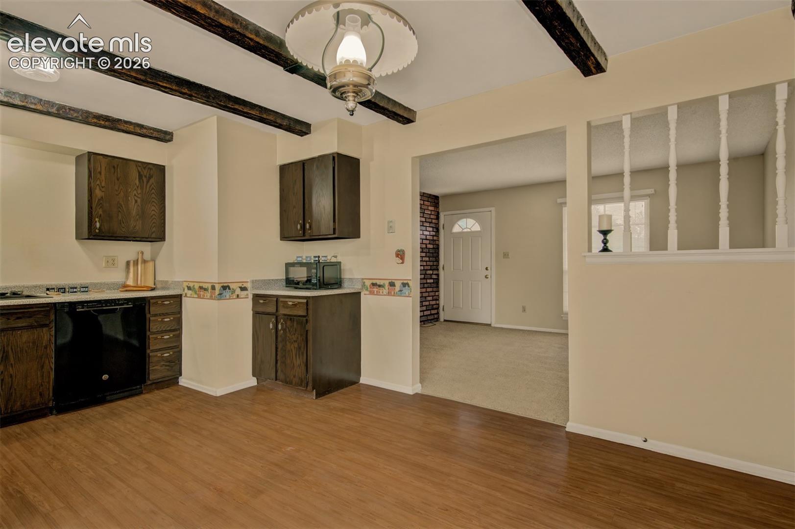 Wood-finish flooring, dark wood cabinetry, exposed wood  ceiling beams