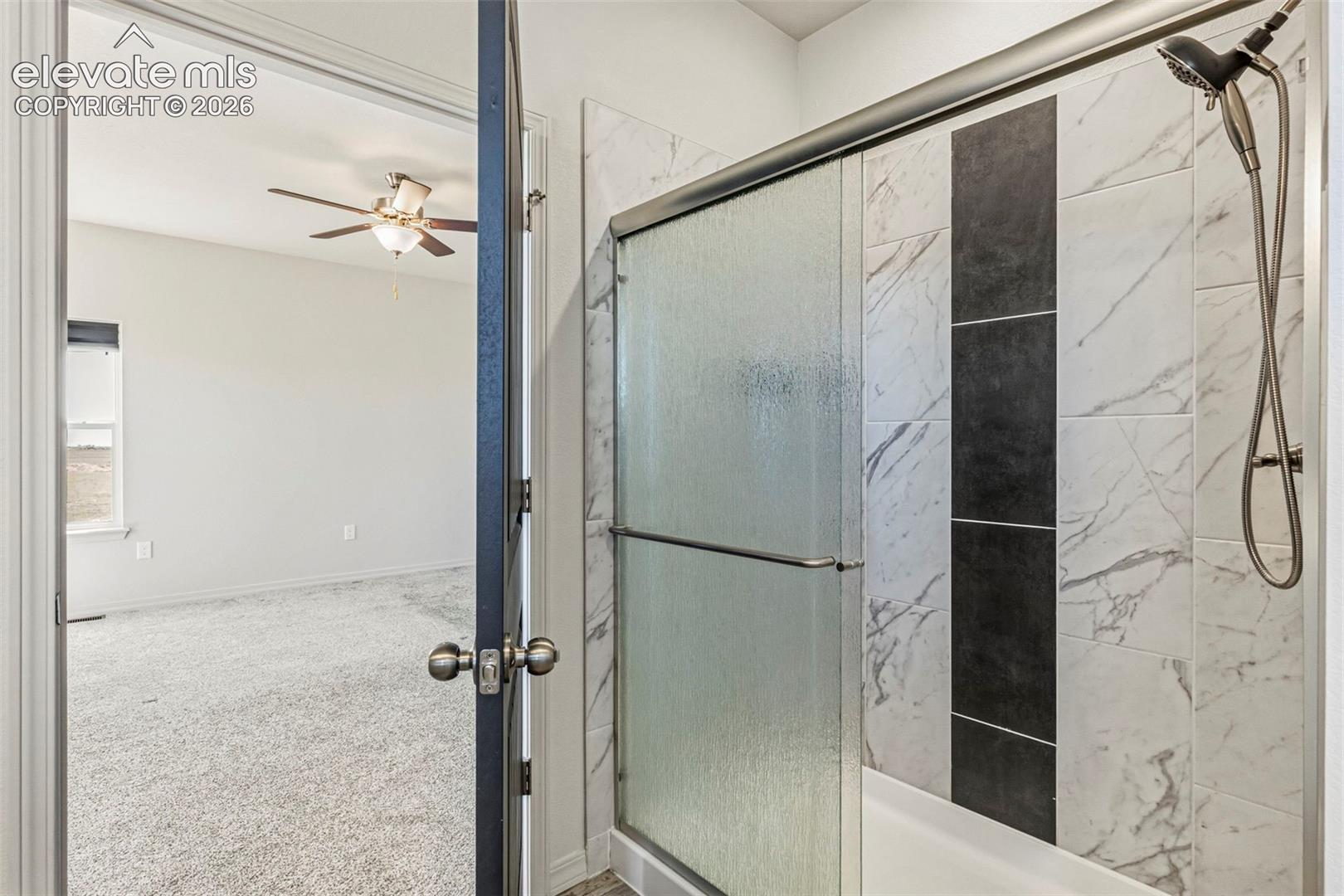 Contemporary shower enclosure with a sliding frosted glass door and a rain shower head
