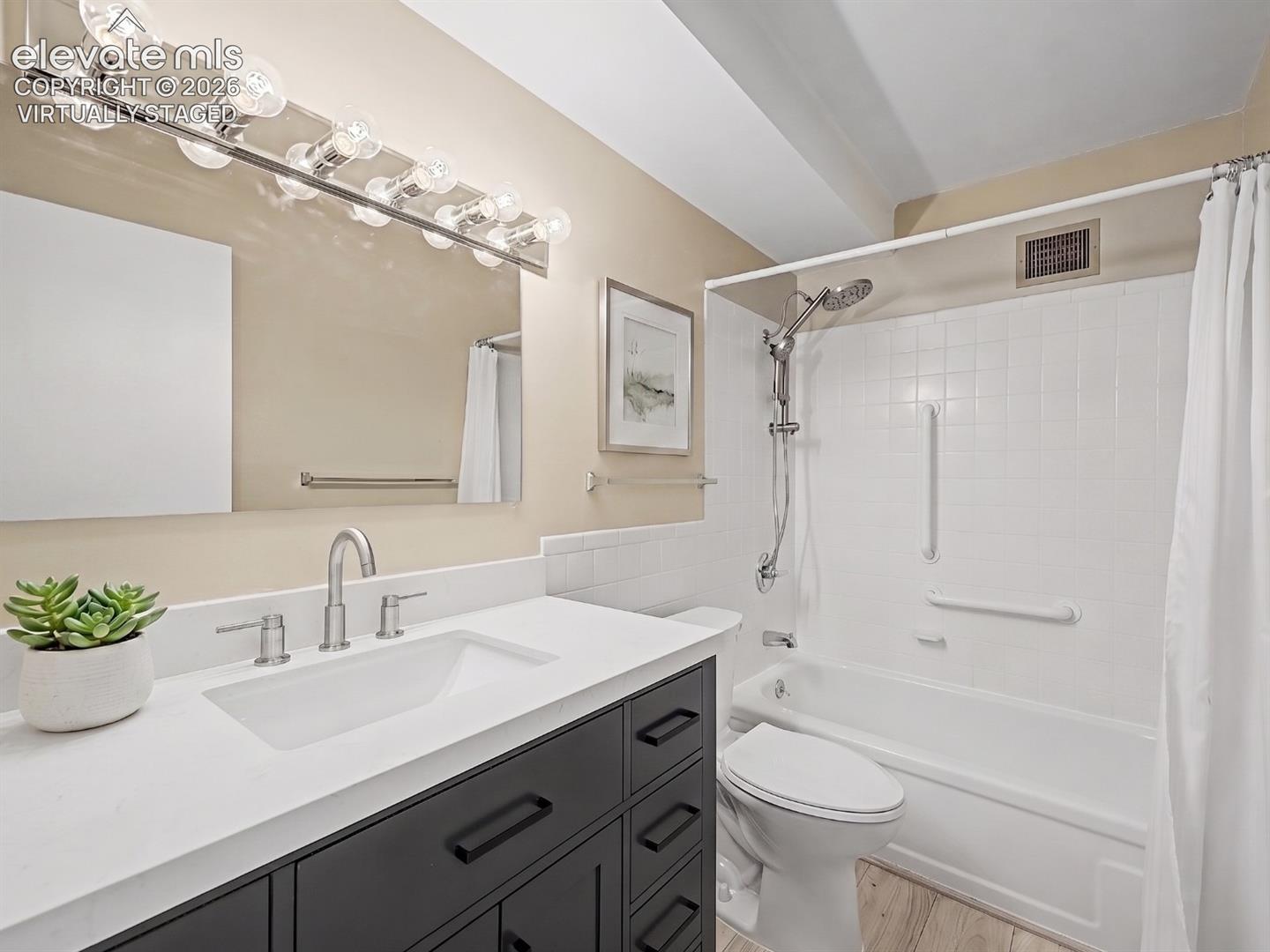 virtually staged Modern bathroom featuring a dark wood-finish vanity with a white countertop and undermount sink, brushed nickel faucet, and coordinating wall-mounted light fixture