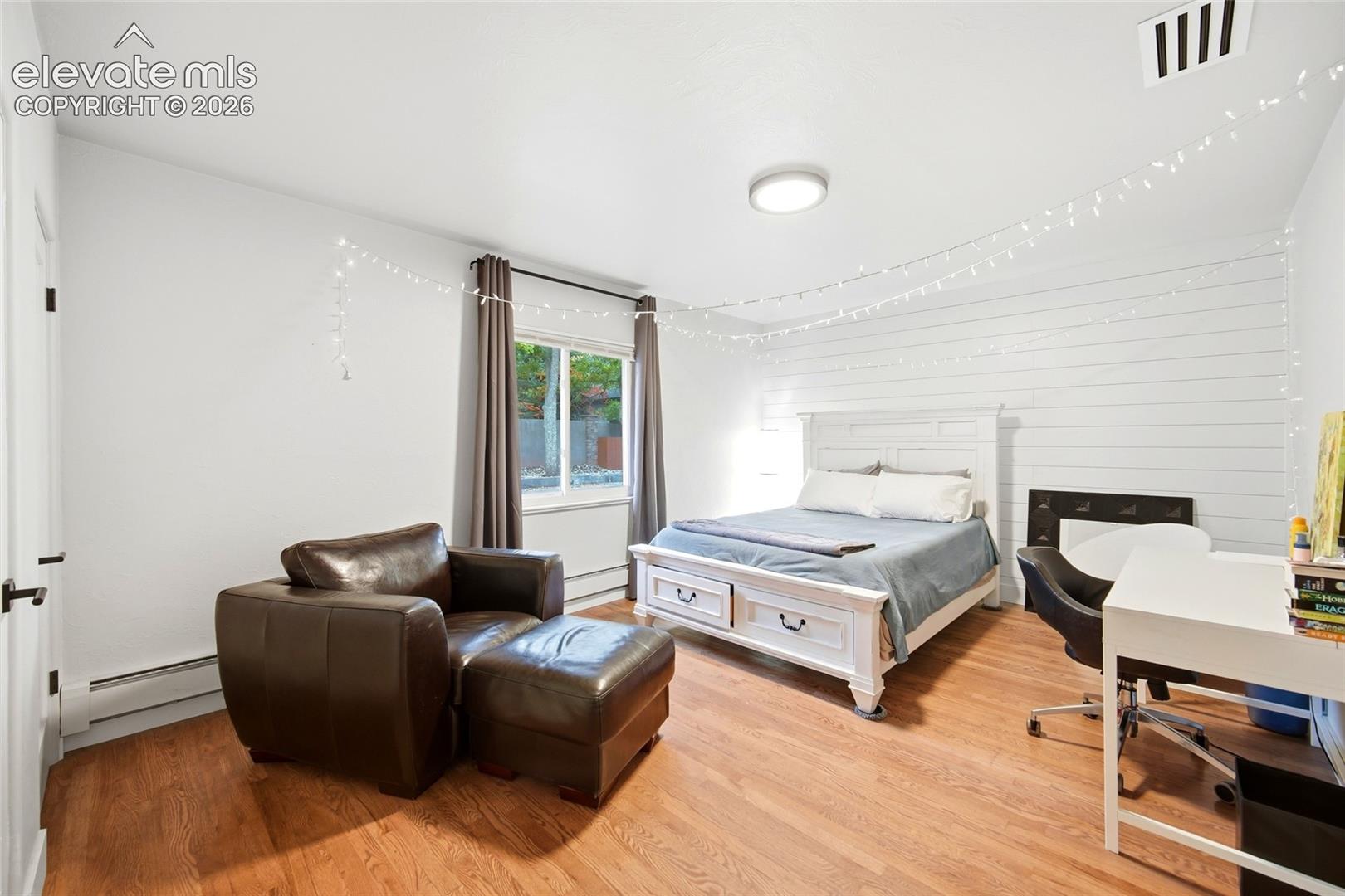 The secondary bedroom on the main floor has views of the pool and back yard. 