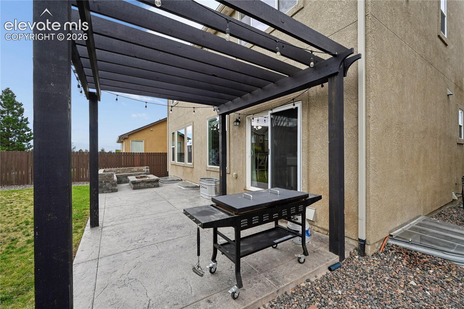 Step outside from the kitchen and your shareable spaces are extended with a stamped concrete patio, pergola, and firepit area.