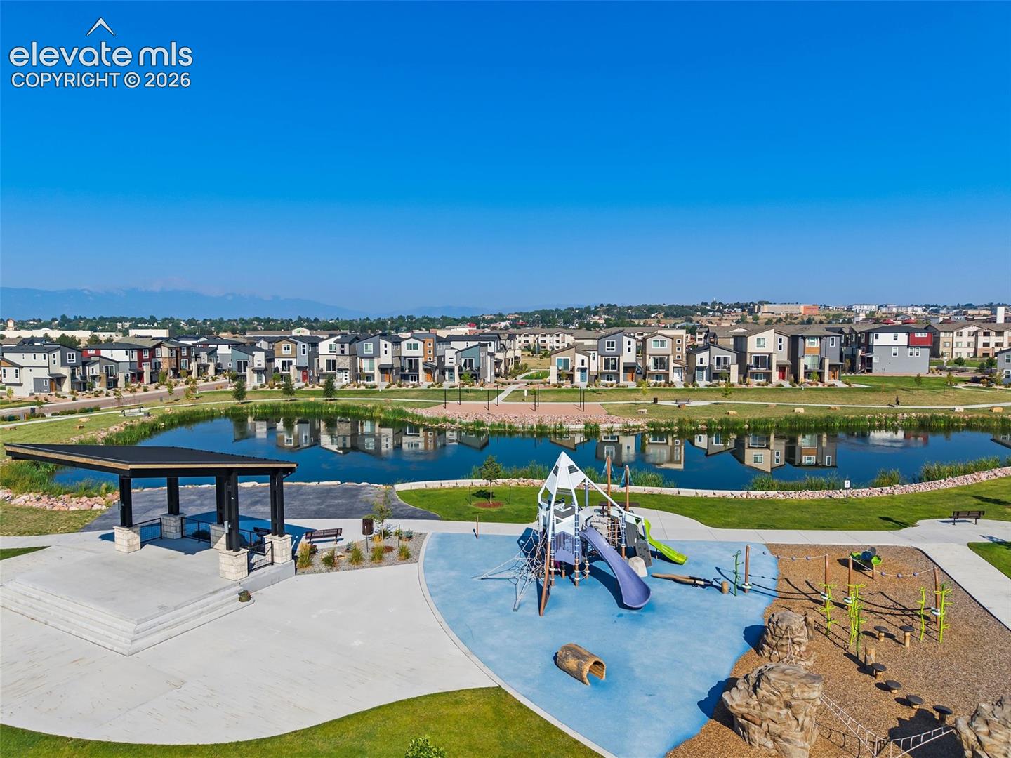 View of the playground and pavilion with the pond at the neighborhood park that is right outside your front door. 