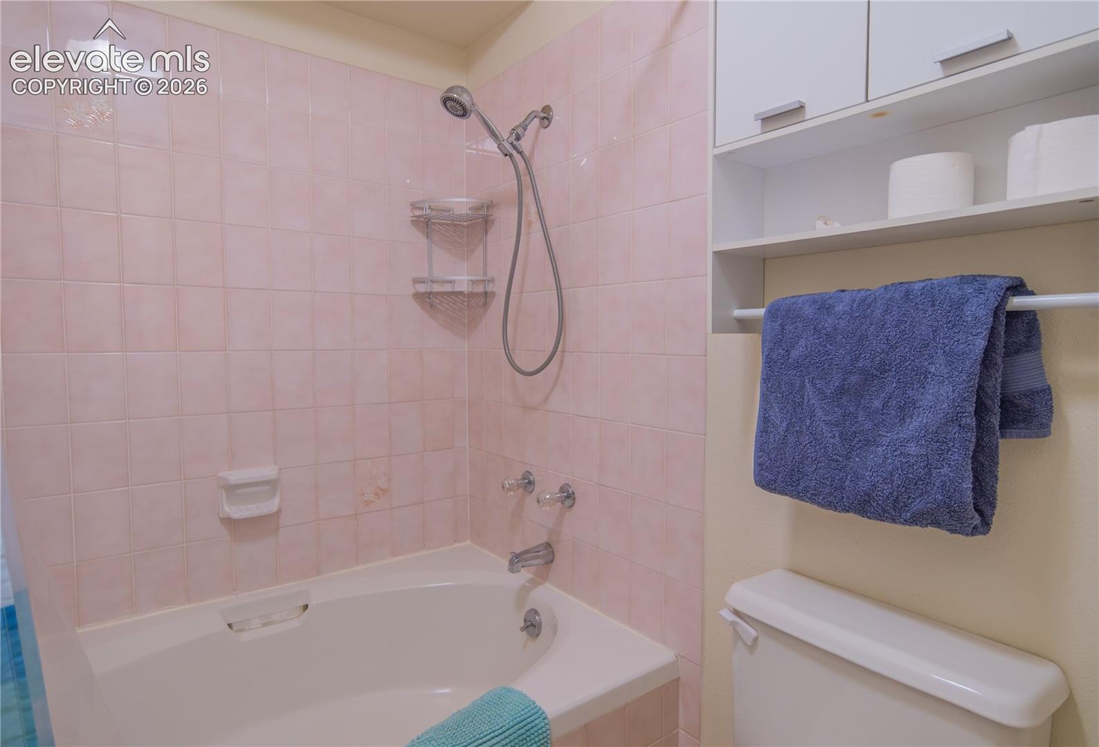 Built-in white bathtub with a shower fixture