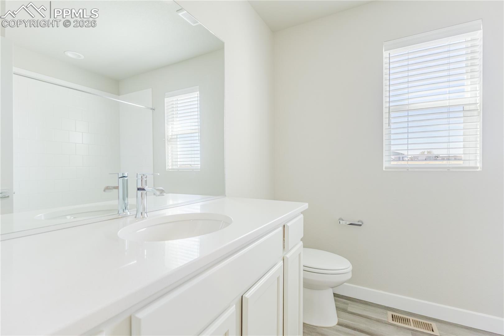 Bathroom featuring vanity, light wood-type flooring, and a shower