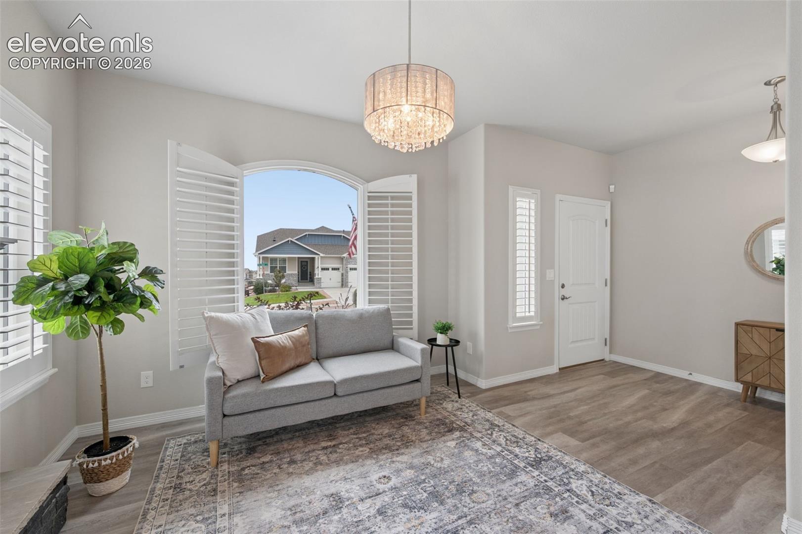 This beautifully designed luxury two-story in Bradley Ranch offers the perfect balance of modern style, thoughtful layout, and incredible mountain views. This stunning home sits on a fully landscaped corner lot and showcases elevated finishes throughout. From the moment you enter, you’re welcomed by a bright, open layout with durable LVP flooring and a versatile front flex space featuring a charming arched window, ideal for a home office, sitting area, or playroom. The main level is designed for both everyday living and entertaining, with a seamless flow into the kitchen and great room. The kitchen is a standout, complete with quartz countertops, stainless steel appliances, a stylish backsplash, 42” cabinetry with upper lighting, and oversized island that anchors the space. A butler’s pantry and large walk-in pantry add both function and convenience. The adjacent great room makes a lasting impression with soaring ceilings, a sleek fireplace, and an expansive wall of windows that fills the home with natural light. Step outside to enjoy the covered patio with stamped concrete, perfect for relaxing or hosting, while taking in the beautifully maintained yard. The oversized three-car garage offers plenty of room for storage and larger vehicles. Upstairs, the layout continues to shine with a spacious loft overlooking the main living area, two well-sized secondary bedrooms, a full bath, and a centrally located laundry room. The primary suite is a true retreat, featuring vaulted ceilings, abundant natural light, and a spa-like bathroom with a soaking tub, double vanity, walk-in shower, heated toilet seat, and a generous walk-in closet. Additional highlights include plantation shutters, a home security system, water filtration system, Wi-Fi controlled sprinkler system, garage shelving, sump pump, and radon mitigation. Located in District 20 and close to parks, trails, shopping, and military bases, this home delivers comfort, style, and convenience in one exceptional package.