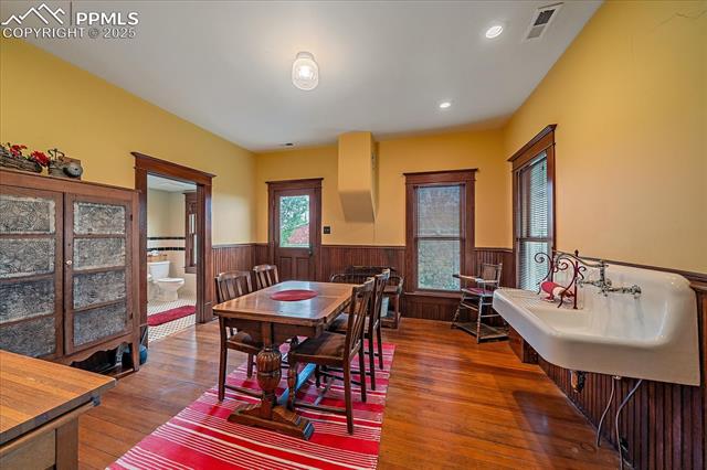 Dining space with wainscoting, wood-type flooring, wood walls, and recessed lighting
