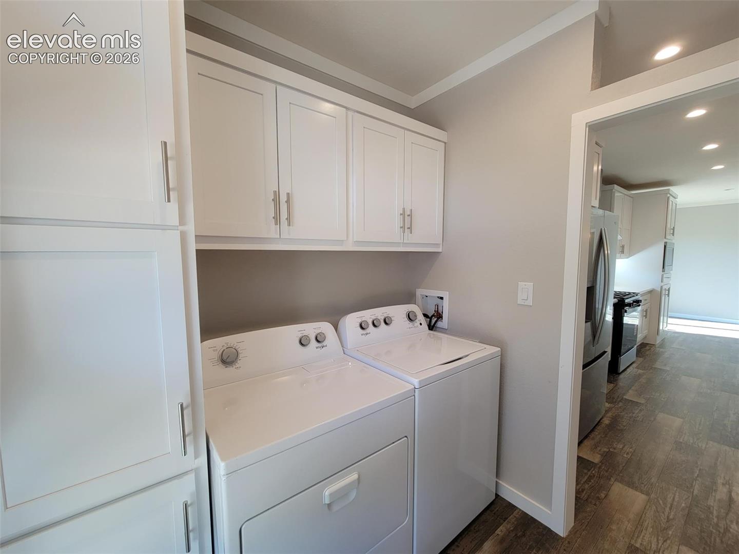 Utility room featuring crisp white shaker-style cabinetry, overhead storage, and recessed lighting