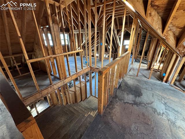 Unfinished attic featuring an upstairs landing