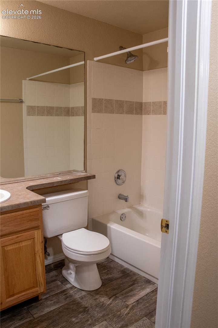 Bathroom featuring a full vanity with an integrated sink, wood-finish cabinetry, and a large wall-mounted mirror