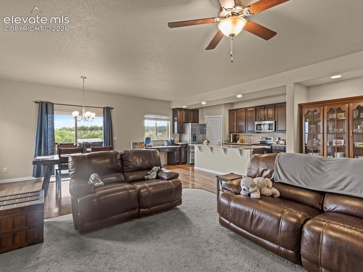 Open-concept living area featuring a ceiling fan, carpeted flooring, and recessed lighting