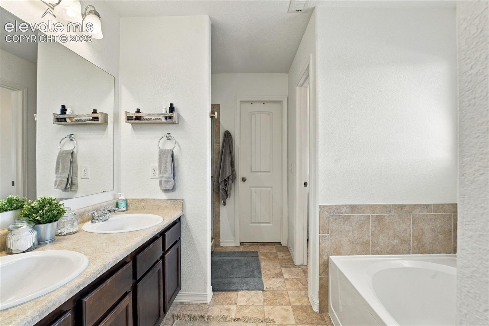 Dual vanity with undermount sinks, laminate countertops, and dark wood-finish cabinetry