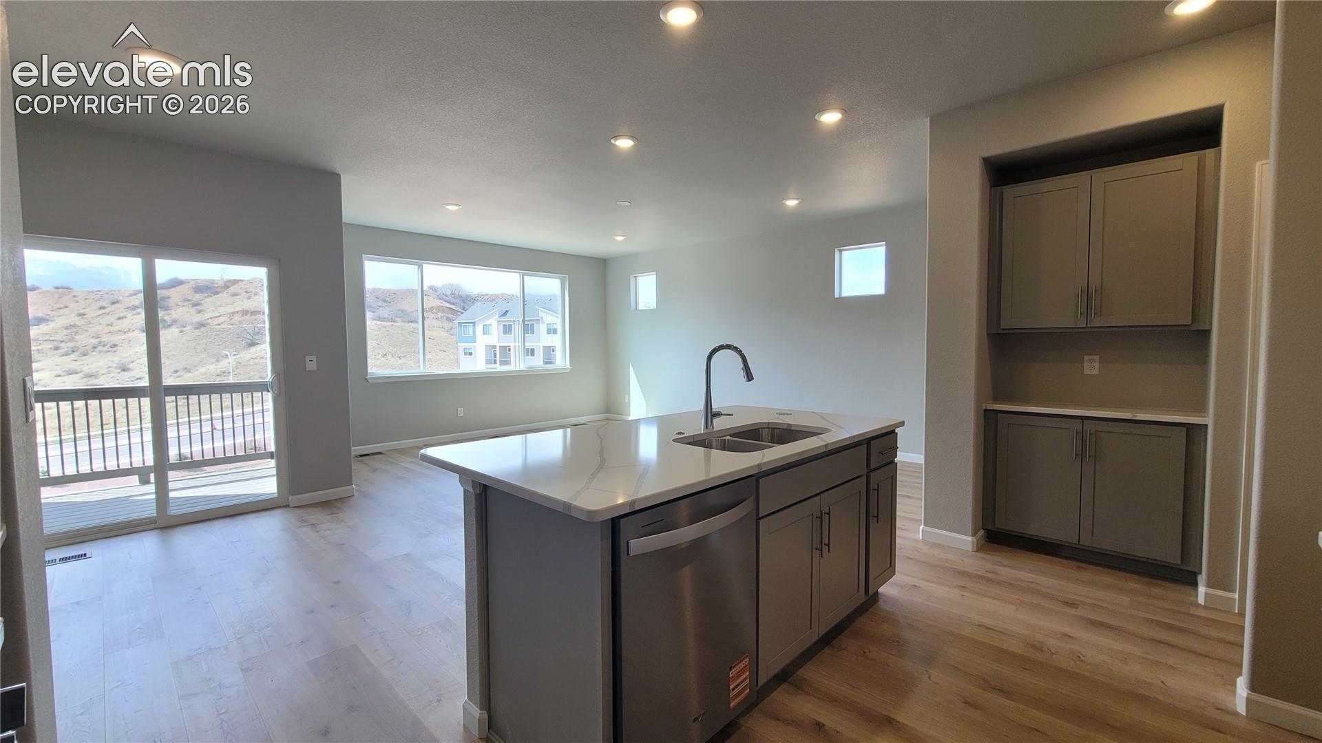 Kitchen with Quartz countertops, pantry, large island, and stainless steel gas range, microwave, and dishwasher!