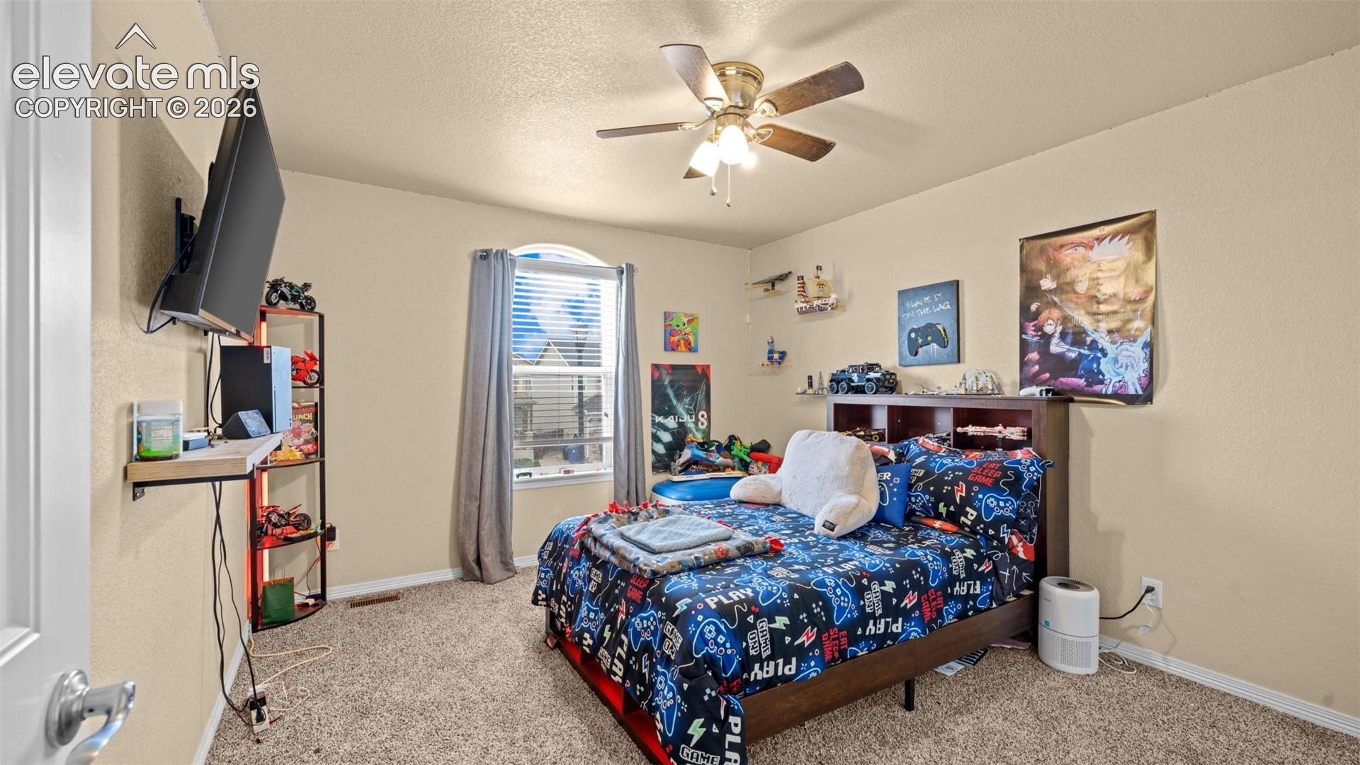 Carpeted room featuring a ceiling fan with light fixture, a window with blinds and drapes
