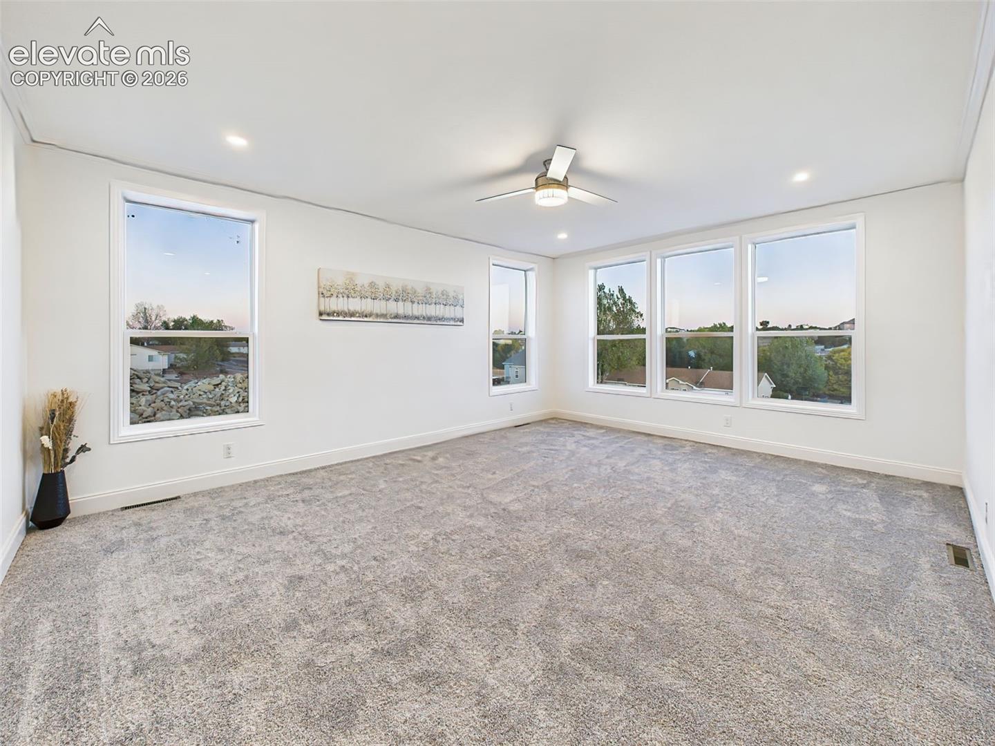 Un-staged version of the main living area, highlighting the fresh paint, new carpet, and seamless flow into the kitchen.