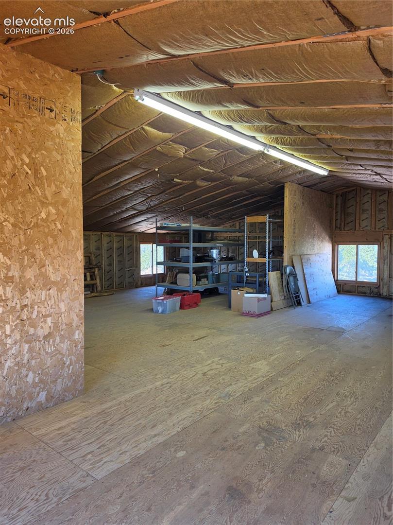 Expansive open space featuring plywood walls and flooring