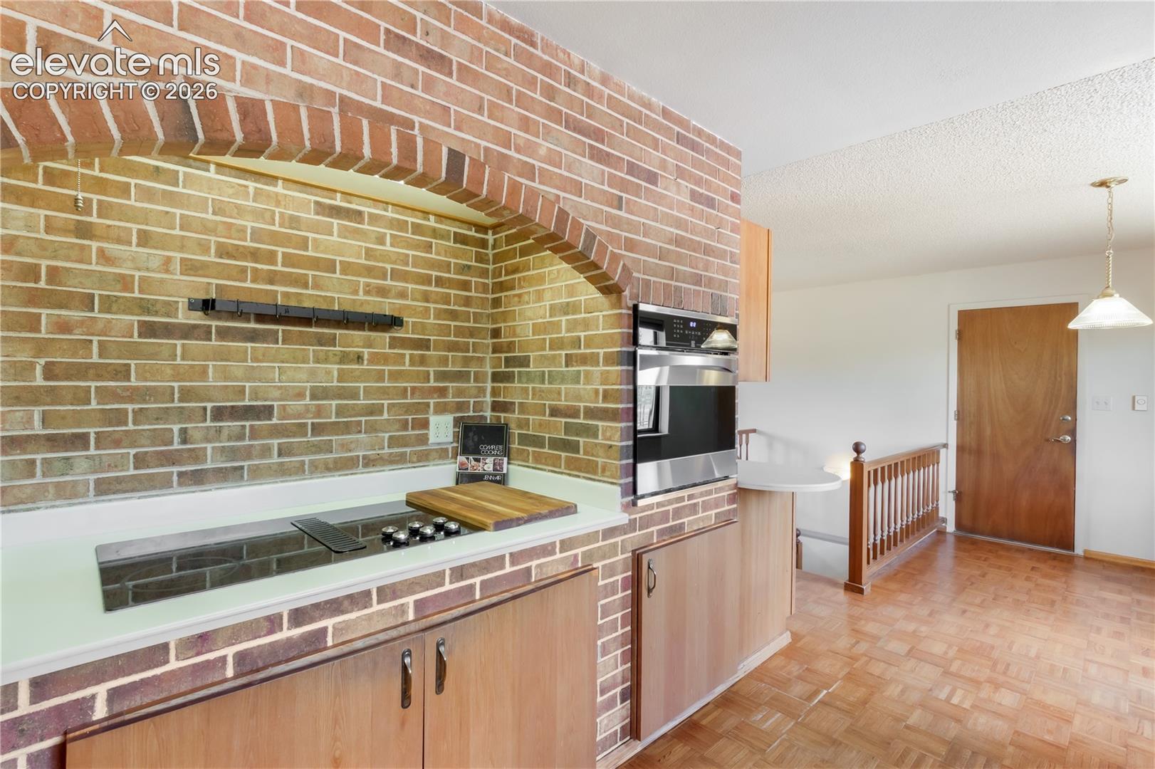 Kitchen with brick archway around cooktop and oven