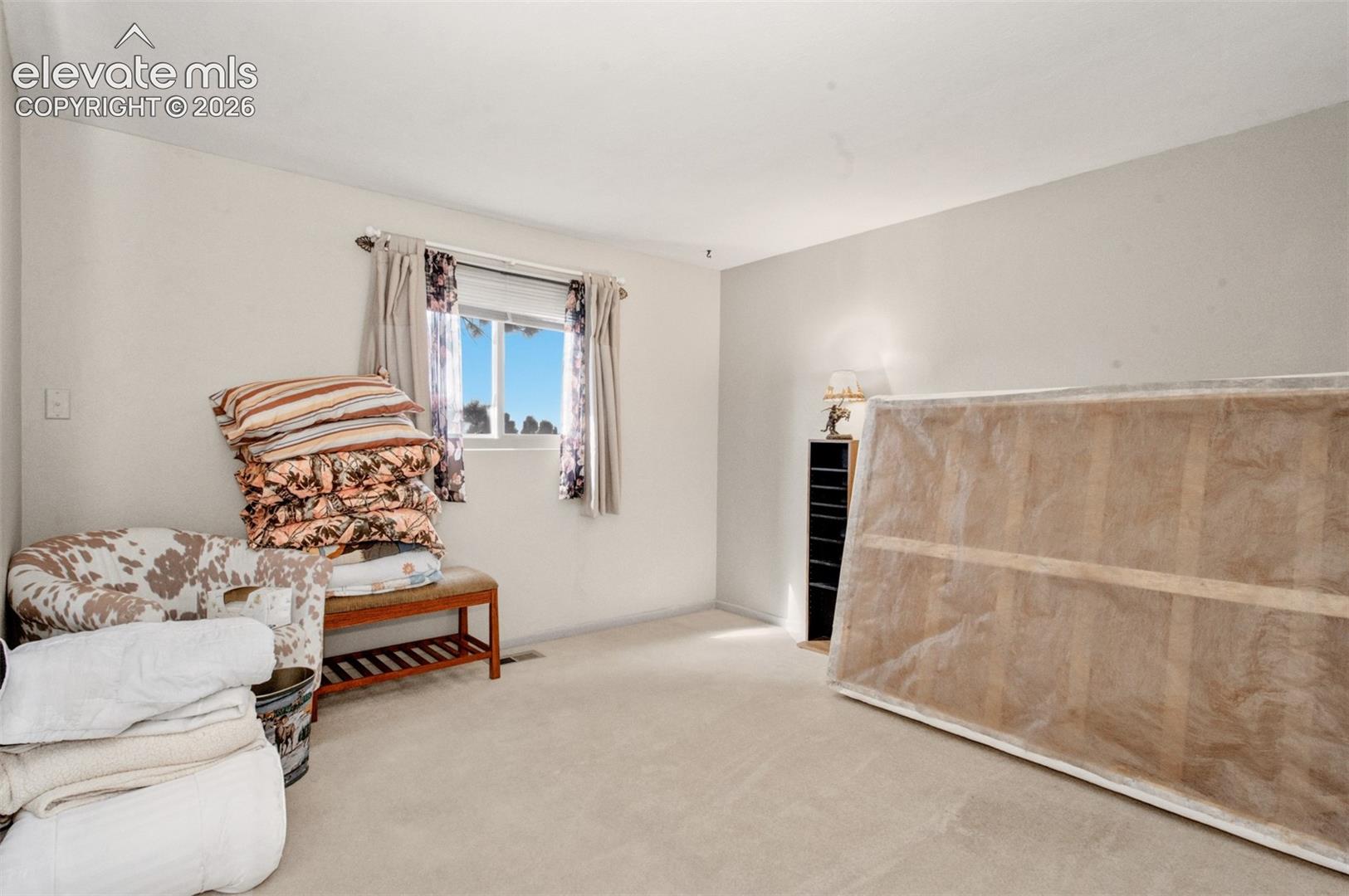 Bedroom two; Wall-to-wall carpeting with light-colored walls and a window with blinds