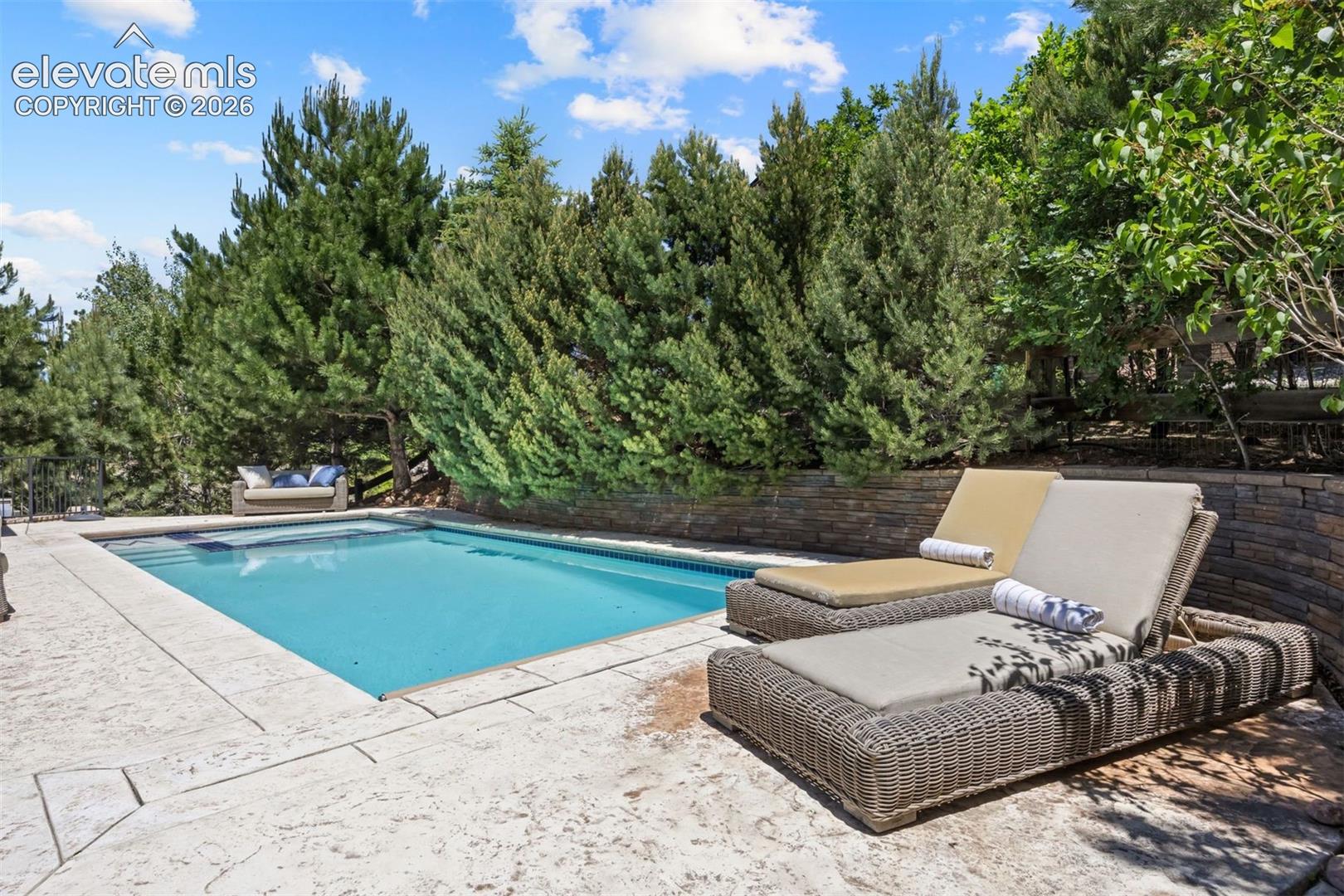 Rectangular swimming pool with a stone patio surround
