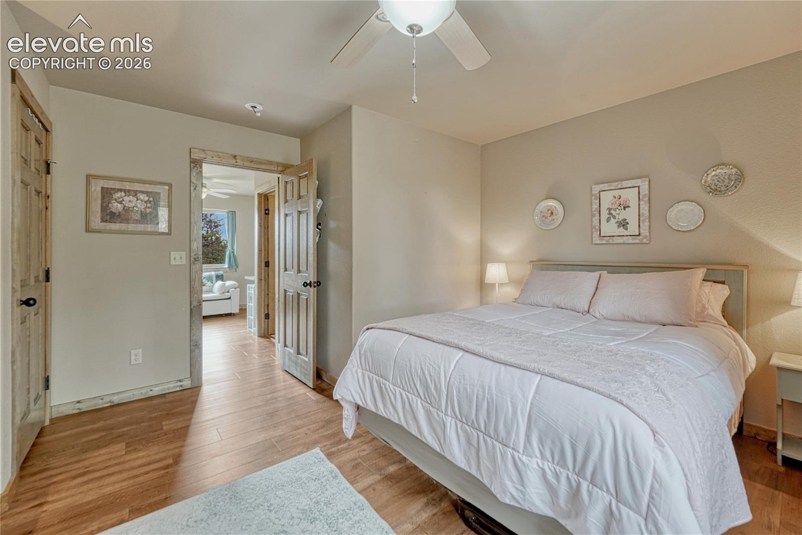 Wood-finish flooring, ceiling fan with integrated lighting, and textured wall finish
