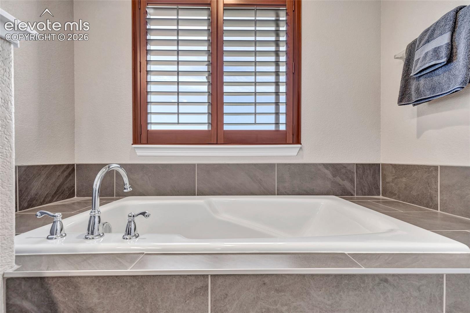 Soaking tub with chrome fixtures and surrounding tilework