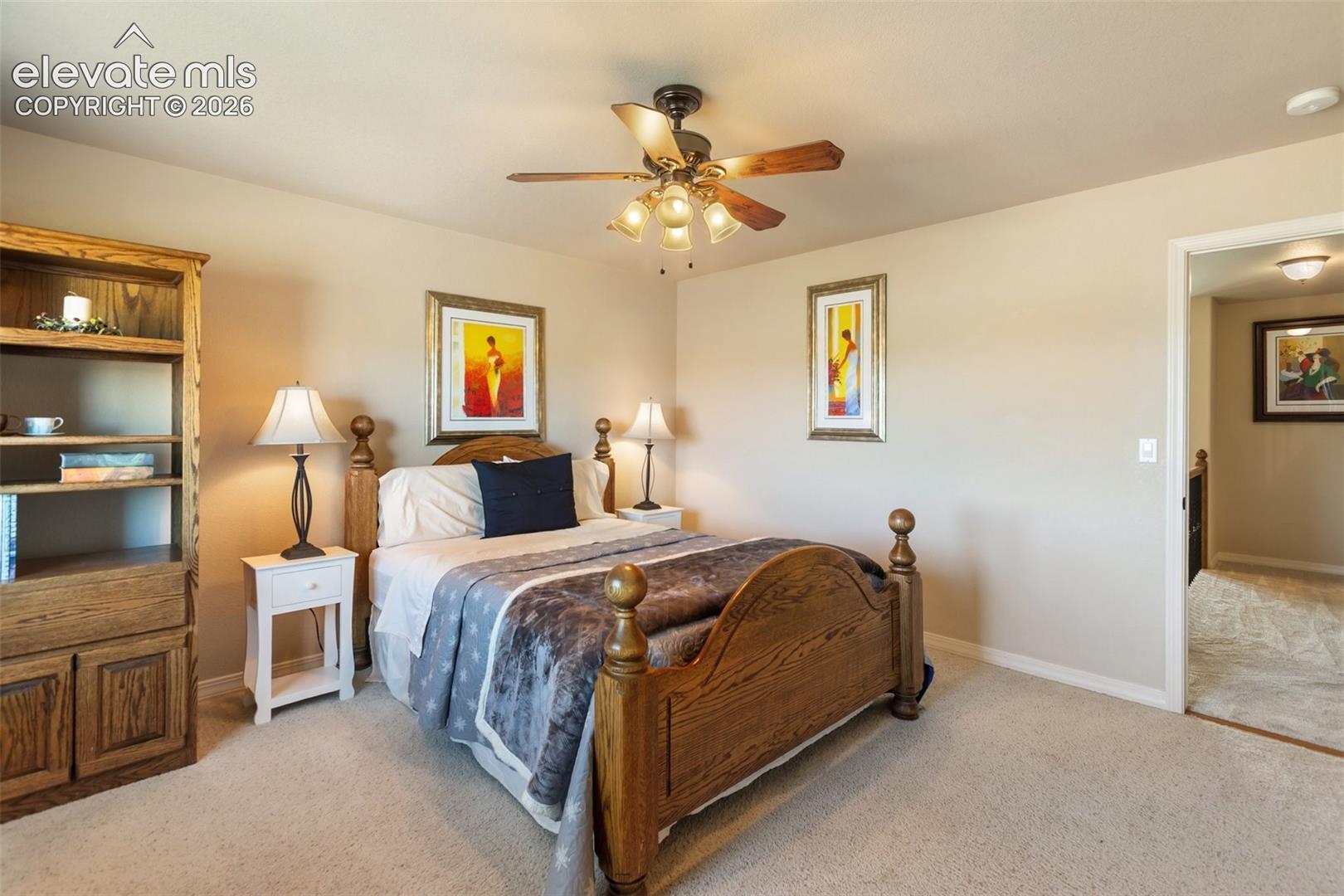 Neutral-toned walls featuring a multi-blade ceiling fan with integrated lighting and wall-to-wall carpeting