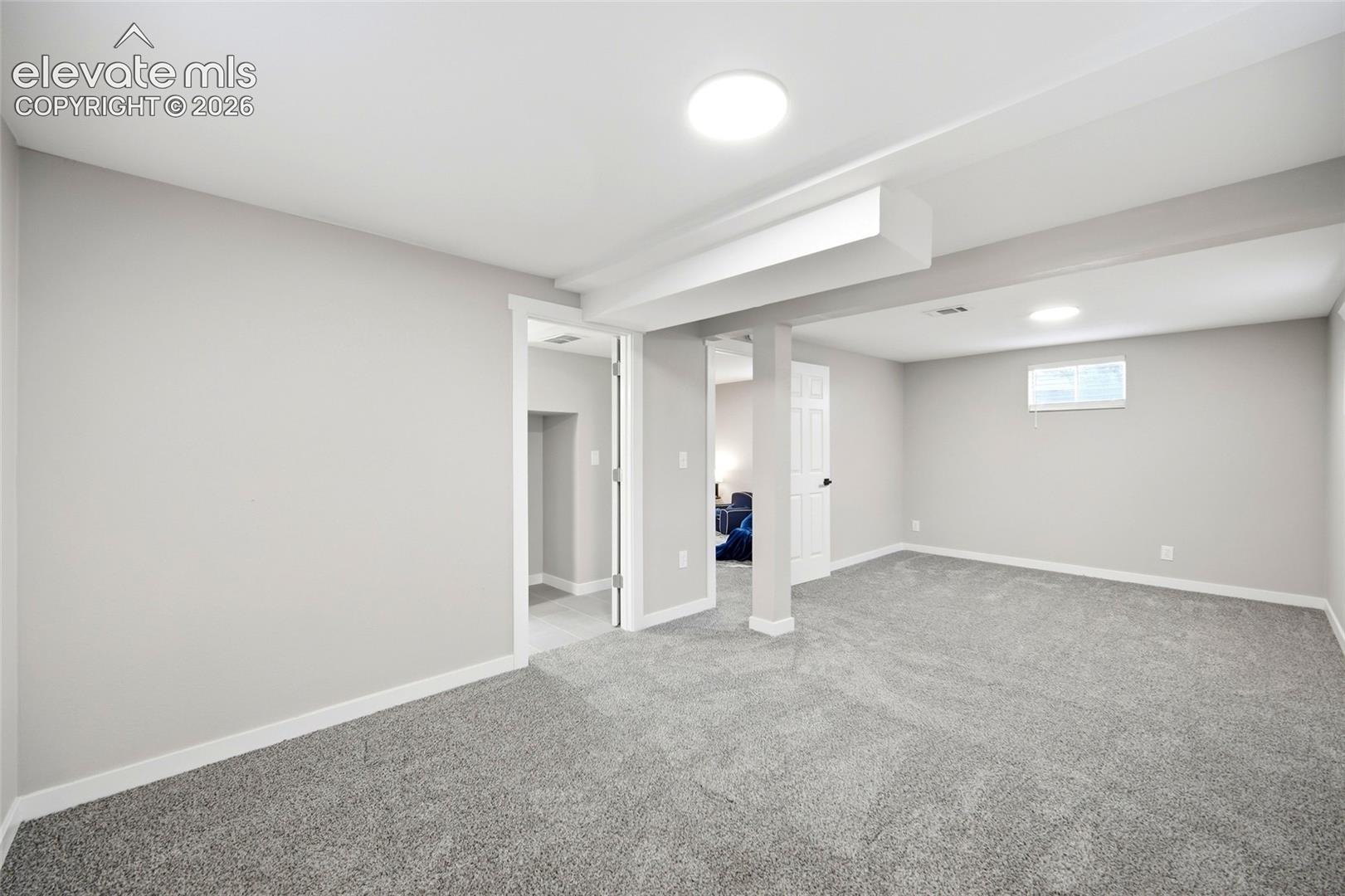 Spacious room with plush gray carpeting, recessed ceiling lighting, and light gray wall finishes