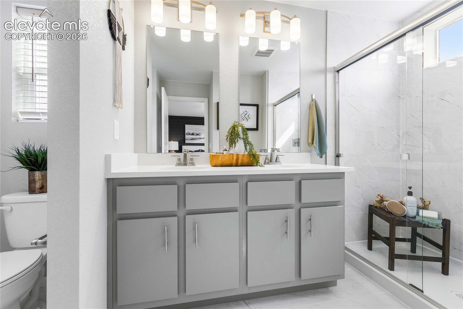 Dual vanity with gray cabinetry, white countertop, and brushed nickel hardware
*photos of a model home*