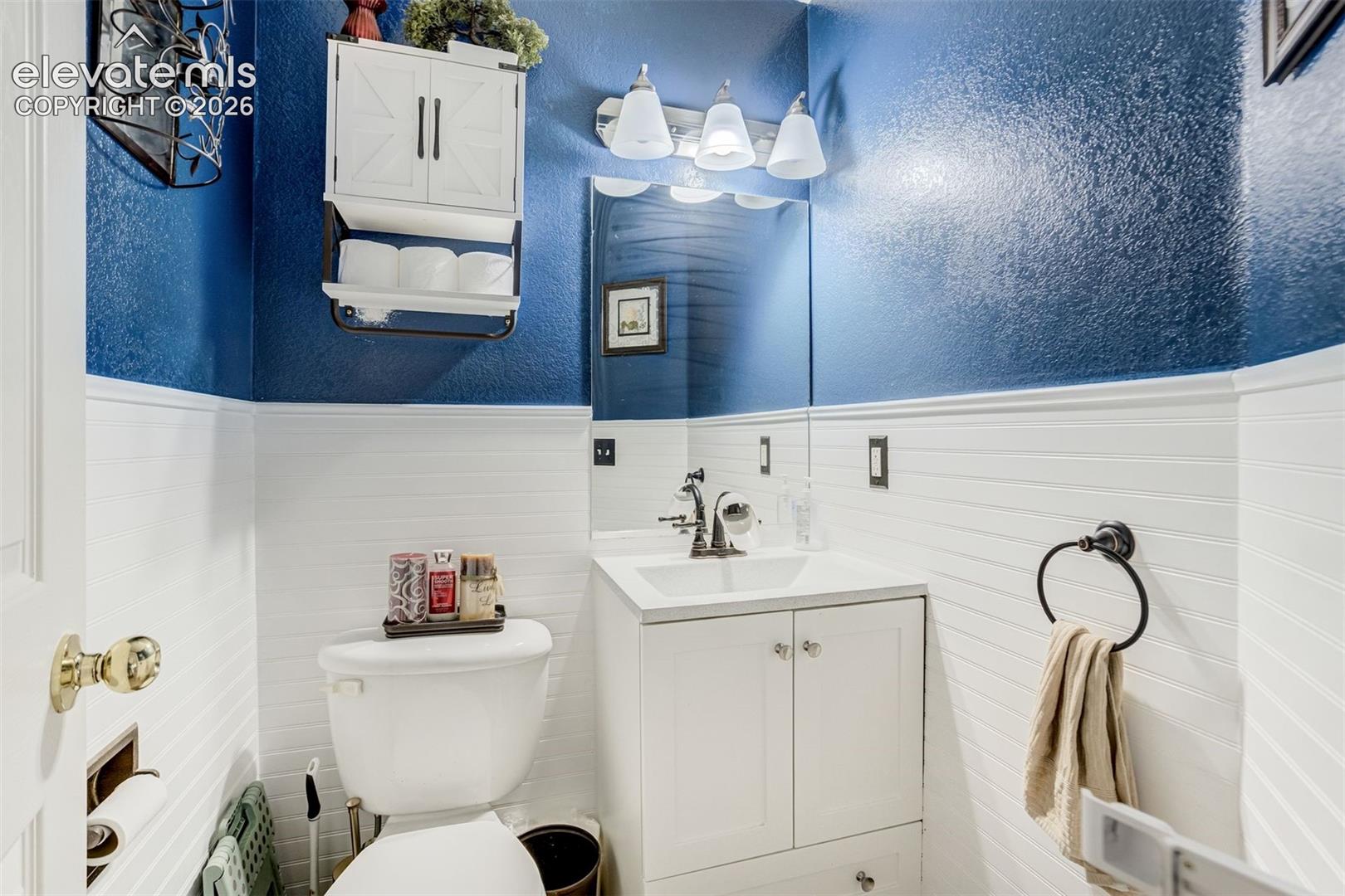 White beadboard wainscoting with a textured blue upper wall