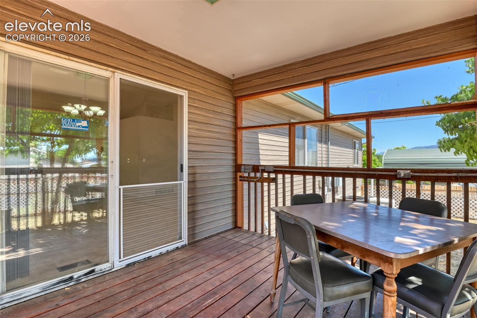 Screened-in porch featuring wood-plank flooring, horizontal lap siding, and expansive rectangular window panels