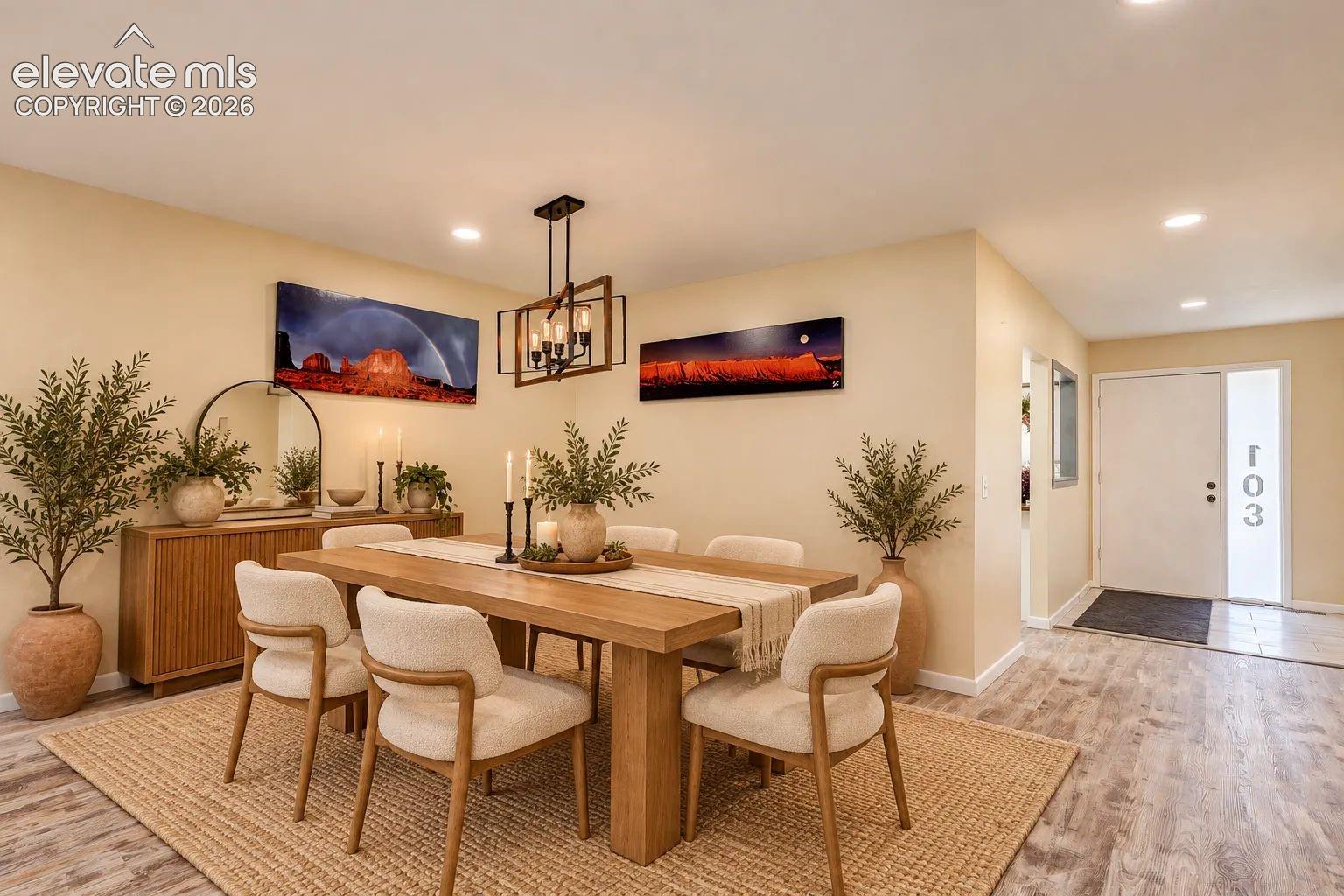 Dining area featuring wood-finish flooring, a geometric metal-frame chandelier, recessed lighting, and a modern entry door with a frosted glass sidelight. AI-Enhanced – furniture/decor digitally added