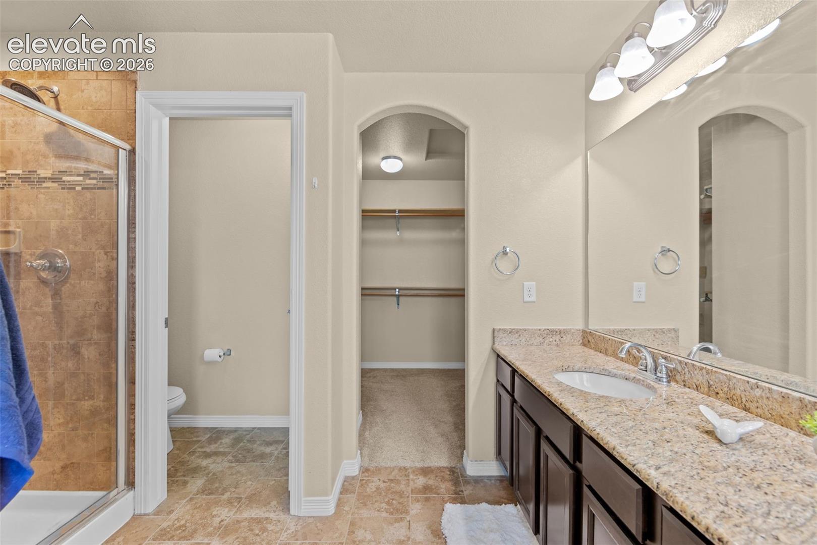 primary bath with dual vanity and linen closet, separate toilet water closet