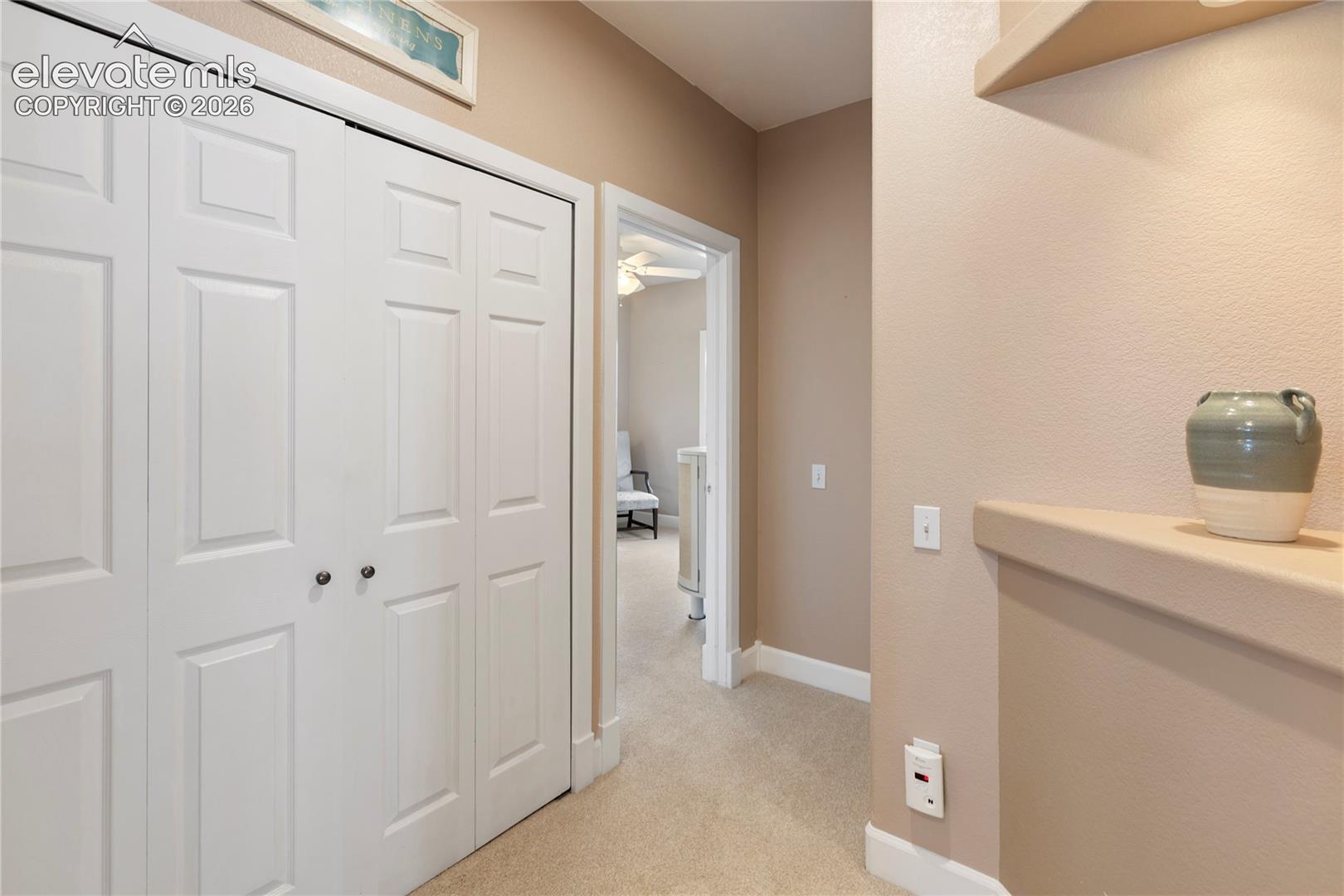 White bi-fold doors, neutral wall tones, and built-in shelving