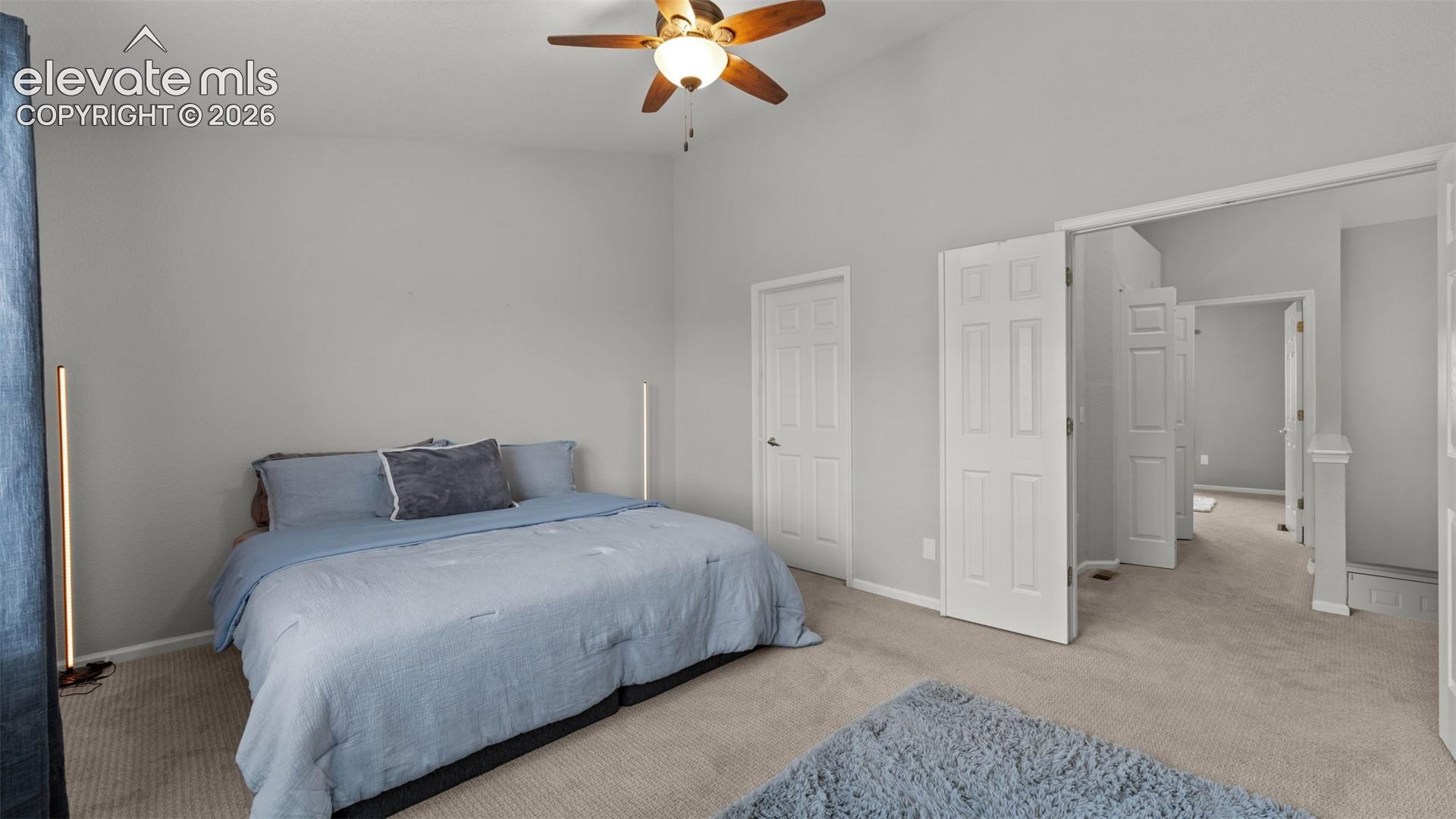 Vaulted ceilings, carpeted flooring, and a ceiling fan with integrated lighting
