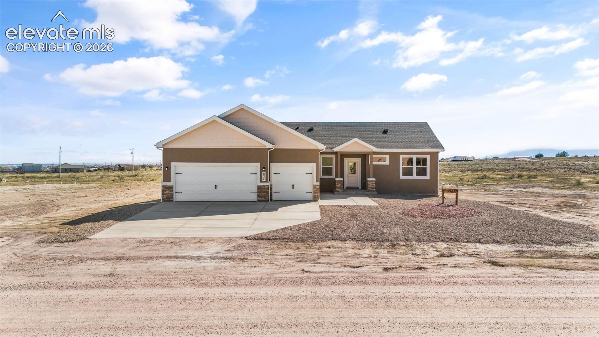 Contemporary single-story residence with a two-car garage, concrete driveway, and stone accents