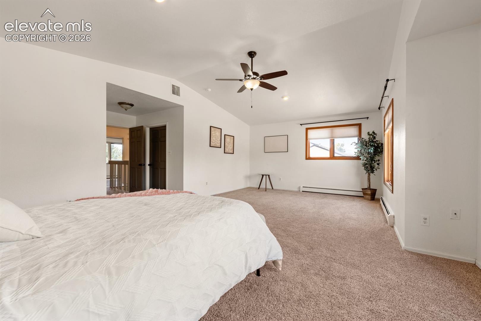 Vaulted ceilings with recessed lighting, brown carpeting, and a ceiling fan with light fixture