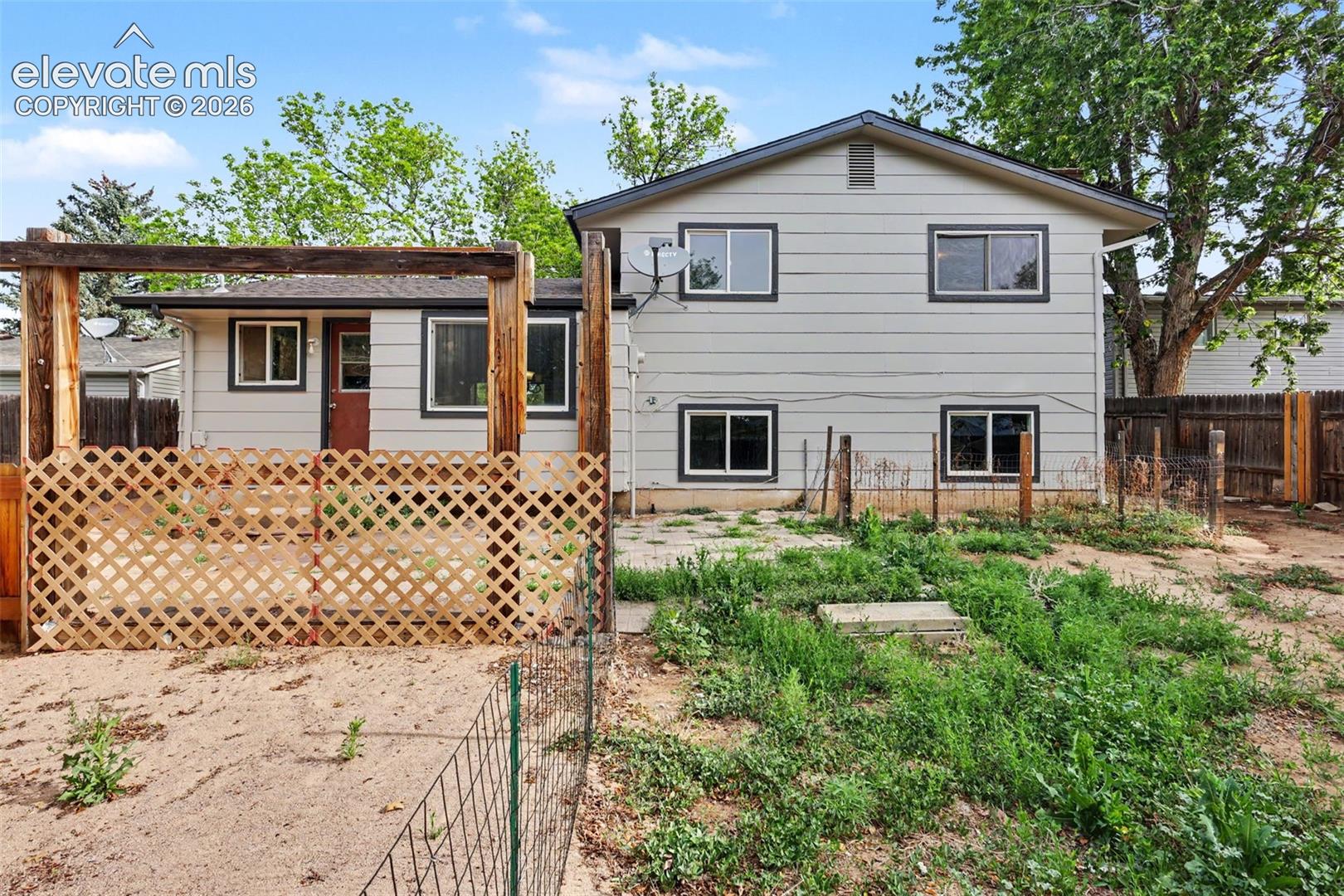 Large backyard with garden space and mature trees.
