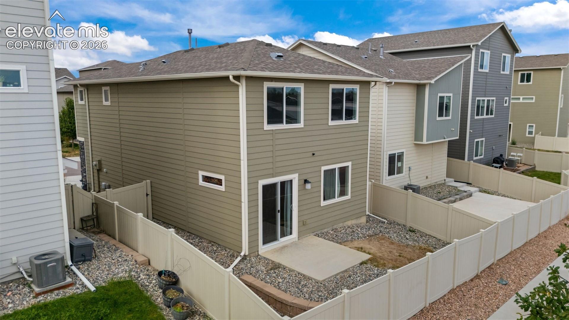 Rear exterior featuring horizontal siding, multiple windows, and a sliding glass door