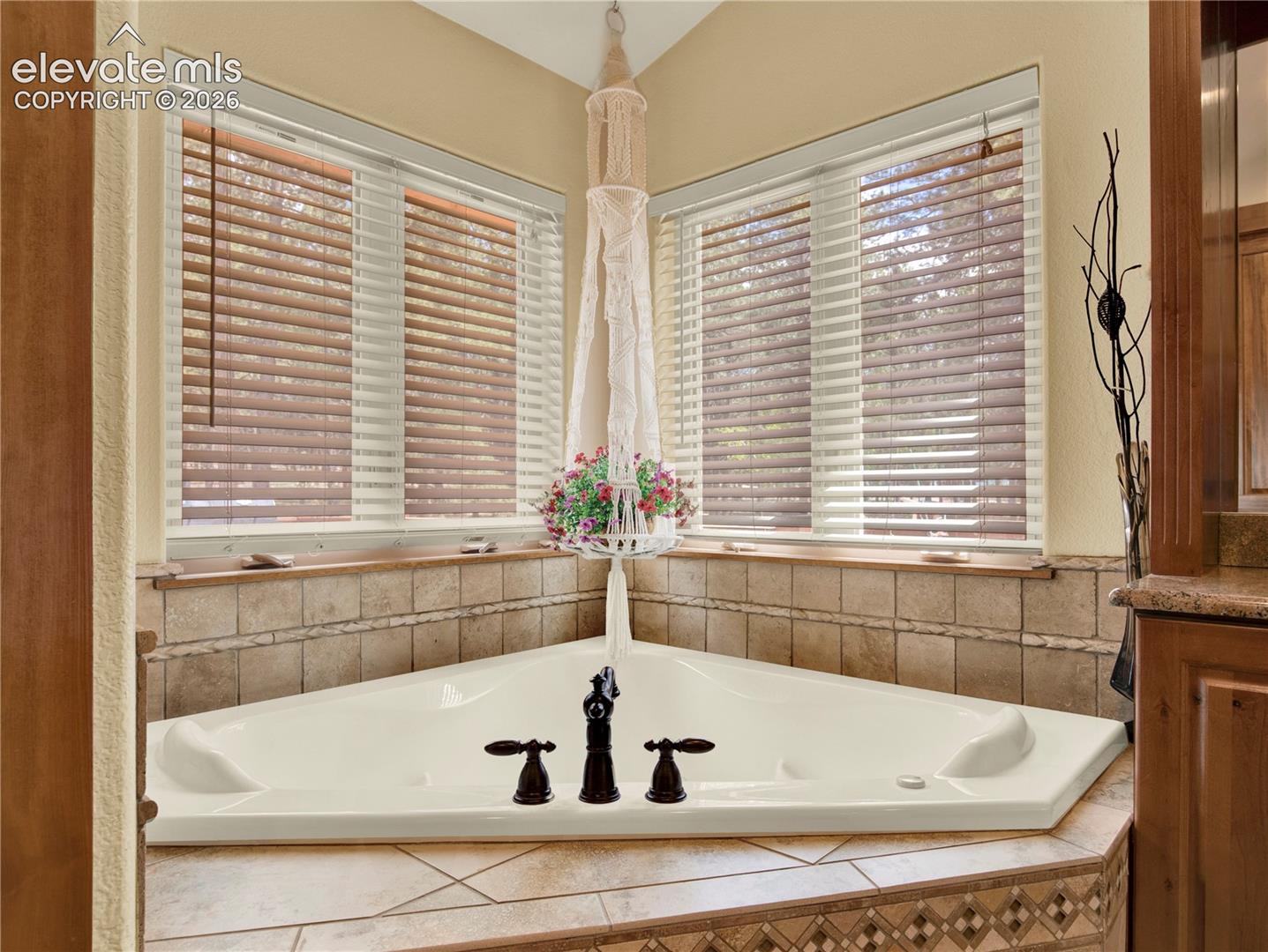 Large soaking heated and jetted tub in the corner of the primary bathroom